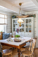 Brightly decorated dining room with wooden furniture and glass cabinet