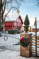 Wooden house painted red with Christmas decorations and snow