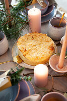 Table set with cake and candles, fir branches as decoration