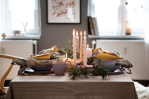 Festive dining table with candles and fir branches