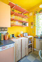 Open shelves with glasses in kitchen with yellow walls