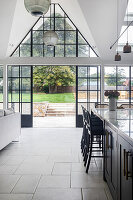 Modern kitchen with glass pendant lights and glass doors to the garden