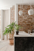 Kitchen corner with brick wall, pendant lights and plants