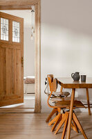 Holztisch und Stühle in minimalistischem Esszimmer mit Holztüren