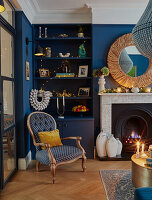 Open shelves next to fireplace in living room with blue walls and Christmas decorations