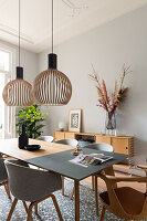 Modern wooden table with grey chairs and pendant lights in the dining room