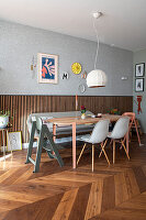 Essbereich mit Holztisch, Stühlen und Wanddekoration