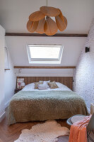 Schlafzimmer mit Dachschräge, natürlichem Licht und Hängelampe