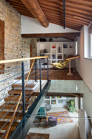 Loft area with gallery, exposed beams and stone wall, modern furnishings