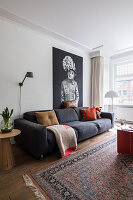 Living room with dark grey sofa, oriental rug and modern artwork
