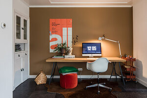 Modern workplace with wooden table and white chair in front of brown wall
