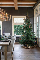 Dining room decorated for Christmas with chandelier and decorated Christmas tree