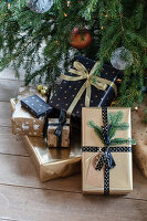 Christmas wrapped presents under a Christmas tree with golden details