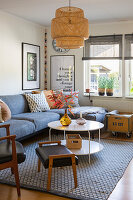 Living room with grey corner sofa, rattan hanging lamp and succulents by the window