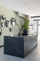 Modern kitchen with black marble island and round wall mirrors