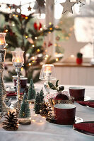Christmas table setting with red coffee crockery and fir trees