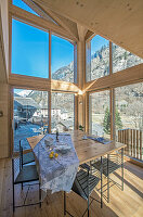 Dining area with wooden panoramic windows in mountain chalet