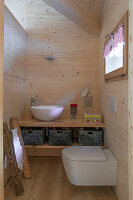 Small bathroom with toilet, wooden paneling and small window