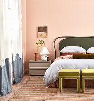 Bedroom with green headboard, pink walls and striped carpet