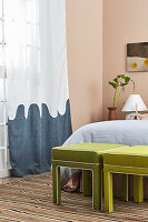 Bedroom with green benches, striped carpet and blue wave curtain