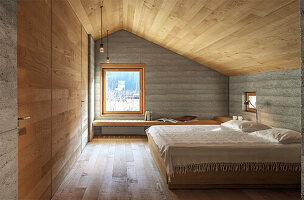 Modern bedroom with wood panelling and window view of the winter landscape