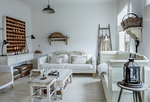 Living room in shabby chic style with white sofa, bench and wooden shelf