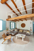 Living room with exposed wooden beams, blue shutters, cosy seating area and gallery