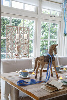 Dining area with rustic wooden table, tea lights and wooden horse