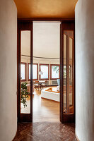 View through door to living room with many windows and wooden floor