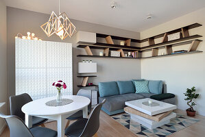 Stylisches Wohnzimmer mit geometrischen Regalen und Designer-Leuchte