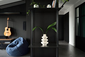 Modernes Apartment in Schwarz mit skulpturaler Vase und Grünpflanze