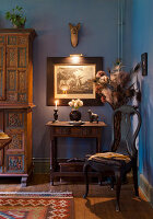 Antique furnished room with illuminated painting on blue wall