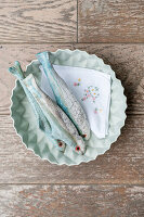 Ceramic fish in a shallow bowl on a wooden background