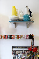 Vintage jugs and colourful bangles on wall shelf display