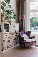 Reading corner with wing chair and rustic wooden cabinet