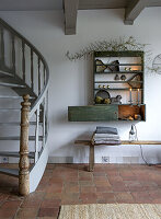 Open-plan living area with wooden spiral staircase and rustic wall shelf