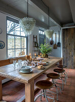 Dining room with long wooden table, rustic stools and Christmas decorations