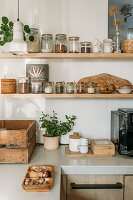 Wooden shelves with spice jars and storage containers, herb pot on the worktop