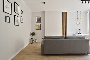 Modernes Wohnzimmer mit grauem Sofa und Bildergalerie