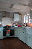 Kitchen with mint-coloured cupboards and tiled splashback