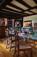 Festively laid dining table with wooden furniture and atmospheric lighting in a rustic dining room