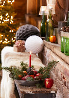 Christmas decoration with red apples and fir branches in a rustic setting