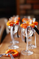 Wine glasses with ribbons made from fabric bows and dried oranges