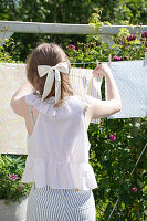 Woman hangs colourful fabric cloths in the garden