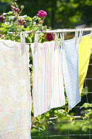 Colourful oilcloths on a washing line in the sunny garden