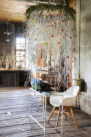 Table with vintage typewriter under hanging floral decoration in rustic room