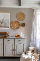 Living room with vintage chest of drawers and rattan decorations