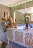 Wooden wicker washbasin cabinet in modern bathroom