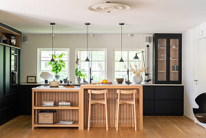 Modern kitchen with kitchen island, bar stools and black fitted cupboards