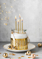 Advent wreath in a glass with golden candles and Christmas baubles